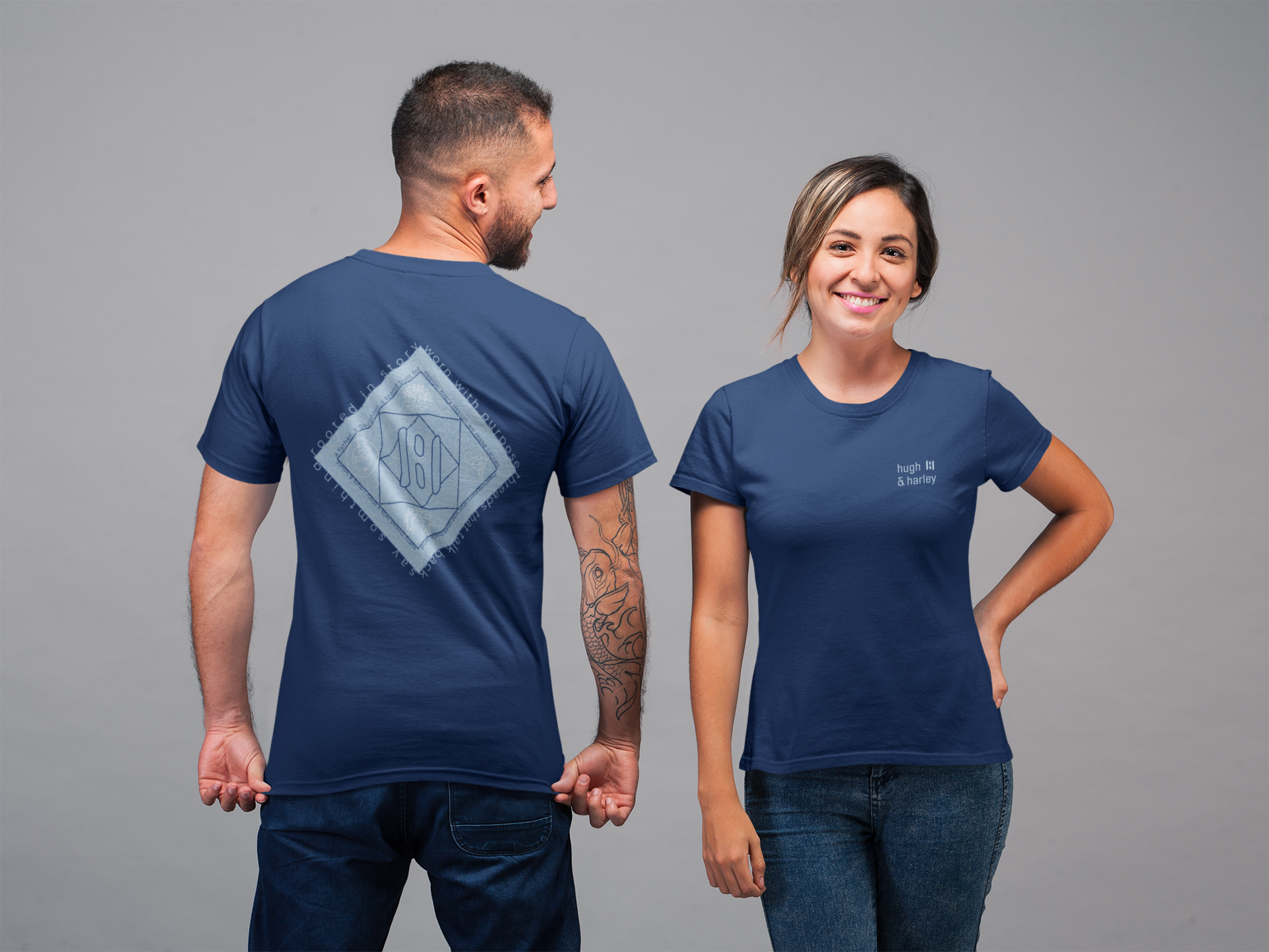 Man and woman wearing blue t-shirts with logos on a gray background